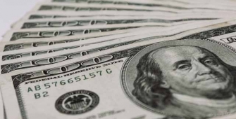 Dollar Trims Gains on Soft Economic Data